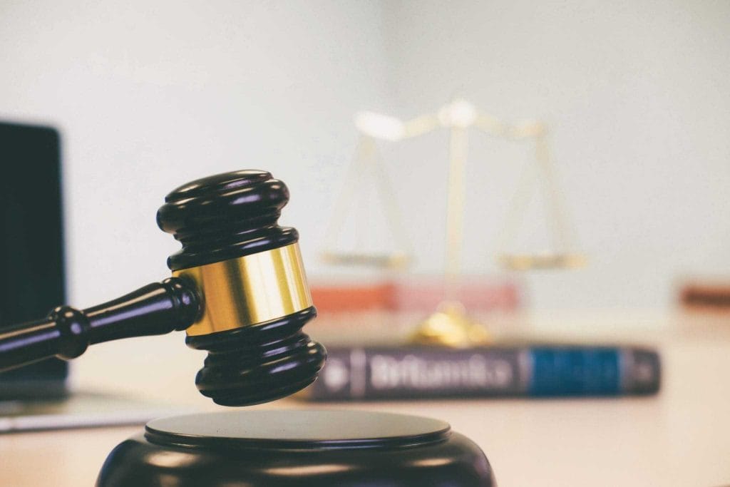 Gavel and judges block symbolizing legal authority and justice with blurred scales of justice in the background Suitable for legal law and justice related content
